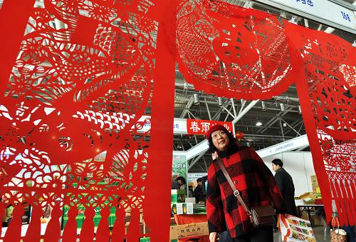 1月7日,一名市民在年貨購物節(jié)上欣賞剪紙作品。 當(dāng)日,2012全國年貨購物節(jié)在山東濟(jì)南舜耕國際會展中心開幕。國內(nèi)外800多家企業(yè)帶來了數(shù)十個門類近萬種名優(yōu)特商品供人們選購。本次會展將持續(xù)12天,期間還將開設(shè)民俗文化一條街,舉行非物質(zhì)文化遺產(chǎn)技藝大師現(xiàn)場表演等活動。 新華社發(fā)(董乃德 攝)