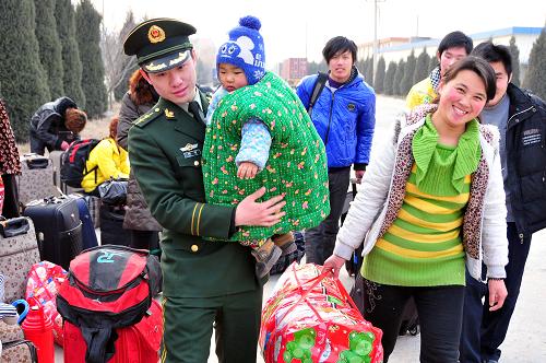 1月15日,“隨車警”劉哲幫助一名農(nóng)民工抱孩子上車。為保證2012年春運(yùn)期間農(nóng)民工包車安全返鄉(xiāng),山東乳山市乳山口鎮(zhèn)邊防派出所6名邊防民警義務(wù)當(dāng)起農(nóng)民工返鄉(xiāng)包車的“隨車警”,隨農(nóng)民工一起乘車,為他們安全回家護(hù)航。新華社發(fā)(劉國(guó)賢 攝)