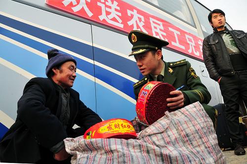 1月15日,“隨車警”劉哲勸說一名農(nóng)民工不要攜帶鞭炮等易燃易爆物品上車。新華社發(fā)(劉國(guó)賢 攝)