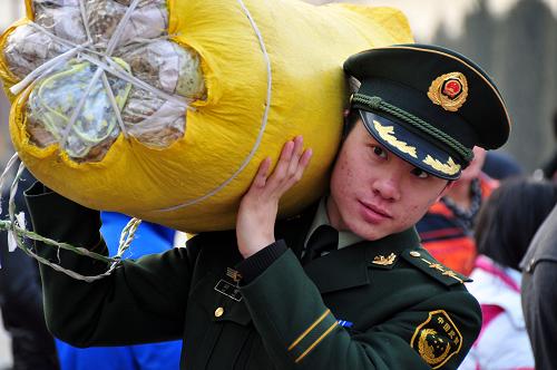 1月15日,“隨車警”劉哲幫助一名農(nóng)民工搬運(yùn)行李。新華社發(fā)(劉國(guó)賢 攝)