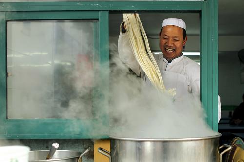 1月25日,在浙江省寧波市開(kāi)拉面館的冶師傅在為顧客拉面。冶師傅是青海西寧人,已經(jīng)來(lái)寧波10年了,春節(jié)基本不回家。新華社發(fā)(胡學(xué)軍 攝)