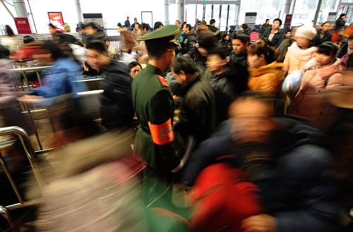 1月28日,旅客在重慶火車北站進(jìn)站乘車。重慶火車北站預(yù)計(jì)當(dāng)日發(fā)送旅客7萬多人次。當(dāng)日是春節(jié)長假的最后一天,各地鐵路迎來節(jié)后客流高峰。新華社記者 李健 攝