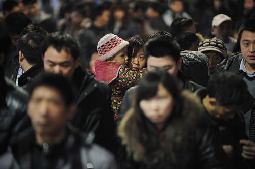 1月28日,一位前往西安方向的母親懷抱小孩在重慶火車北站進(jìn)站乘車。重慶火車北站預(yù)計(jì)當(dāng)日發(fā)送旅客7萬多人次。新華社記者 李健 攝