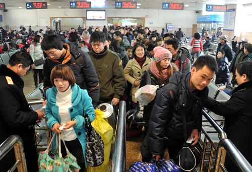 1月28日,在山東濟(jì)南火車站,旅客在排隊(duì)檢票上車。新華社記者 徐速繪 攝