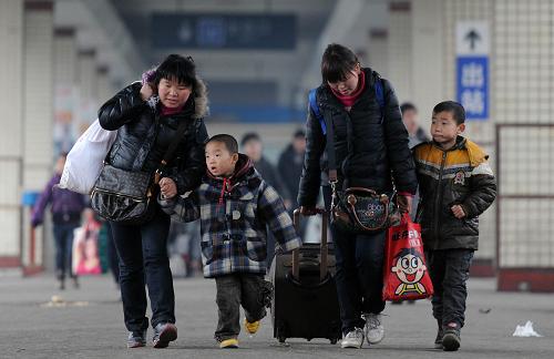 1月28日,長沙火車站站臺(tái)上,兩名旅客拿著行李牽著孩子趕車。新華社記者 李尕 攝