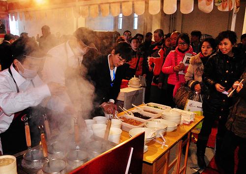 2月18日,2012第三屆中國創(chuàng)業(yè)加盟品牌展覽會上,觀眾在某餐飲項(xiàng)目展位前排隊(duì)品嘗小吃。新華社發(fā)(李佳明 攝)