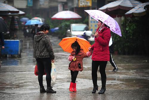 在廣西桂平市街頭,市民在雨中閑聊(3月17日攝)。新華社記者 黃孝邦 攝