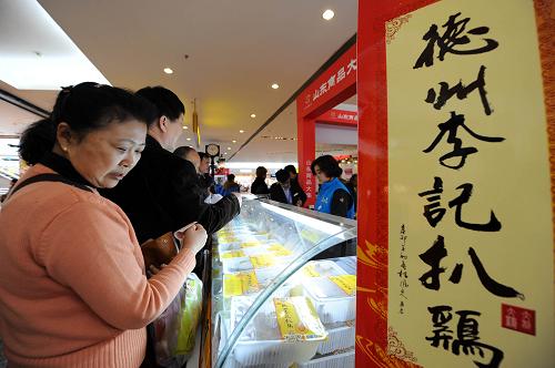 3月23日,北京市民在“山東商品大集”上選購(gòu)德州扒雞。新華社記者 李鑫 攝
