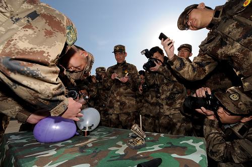 青年記者觀看軍隊(duì)業(yè)務(wù)能手展示氣球上焊接(4月7日攝)。新華社記者 李鑫 攝