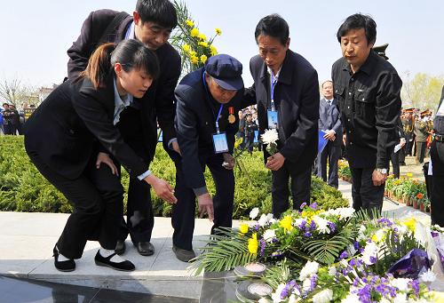 4月8日,93歲的臺(tái)兒莊大戰(zhàn)參戰(zhàn)人員張玉泉(中)為無(wú)名英雄墓點(diǎn)亮長(zhǎng)明燈。新華社發(fā)(高啟民 攝)
