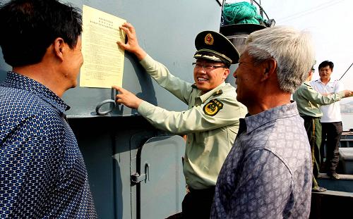5月10日,威海孫家疃邊防派出所民警在漁船上張貼禁漁等相關(guān)法律規(guī)定宣傳單。隨著6月1日禁漁期的臨近,威海公安邊防支隊(duì)聯(lián)合漁政部門加大對(duì)漁民出海作業(yè)的監(jiān)管力度。民警們通過張貼宣傳單、登船走訪等多種形式引導(dǎo)和教育漁民自覺遵守規(guī)定,依法出海作業(yè)。新華社發(fā)(錢程 攝)