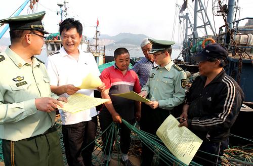 5月10日,威海孫家疃邊防派出所民警登上漁船向漁民宣傳禁止非法越界捕撈等相關(guān)法律規(guī)定。新華社發(fā)(錢程 攝)