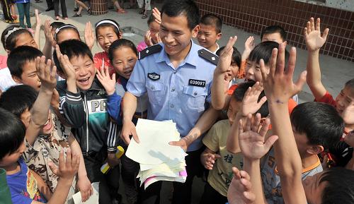 5月11日,寧老莊鎮(zhèn)派出所民警李廣賀(中)在組織寧老莊中心小學(xué)學(xué)生開(kāi)展暑期安全知識(shí)問(wèn)答游戲。當(dāng)日,安徽省阜陽(yáng)市寧老莊鎮(zhèn)派出所的民警來(lái)到附近的寧老莊中心小學(xué),為這里的留守兒童們講授交通以及暑期安全的相關(guān)知識(shí)。安徽省阜陽(yáng)市是我國(guó)農(nóng)民工輸出大市,為了讓在外務(wù)工的農(nóng)民工安心工作,近年來(lái),阜陽(yáng)市公安局組織各基層派出所民警走訪鄉(xiāng)村留守兒童學(xué)校,增強(qiáng)孩子們的安全防范意識(shí)。新華社記者郭晨 攝