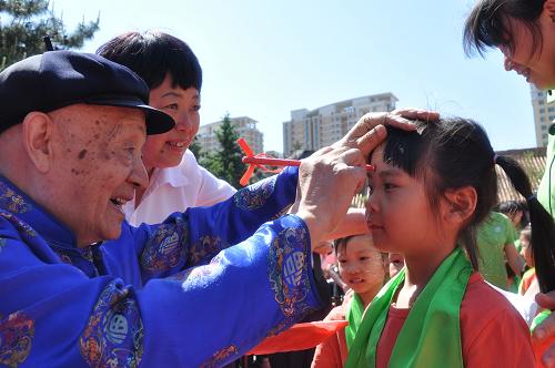 5月25日,學(xué)前兒童在吉林文廟開筆禮上參加“朱砂開智”儀式。新華社發(fā)(王明銘 攝)