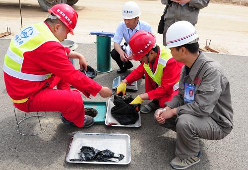 5月31日,雷西高速公路路面第四標段施工單位中鐵五局機械化公司工程人員正在對鋪筑的路面按照標準化要求進行檢驗取樣。新華社記者 范培珅 攝
