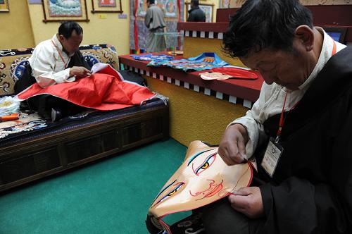 6月9日,墨竹工卡縣非遺傳承人嘎瑪群培(右)展示康卡堆秀的制作技藝。新華社記者 文濤 攝