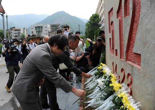 6月15日,日本國際醫(yī)療隊和救援隊隊員代表在北川老縣城向地震遇難者獻花。新華社 發(fā)