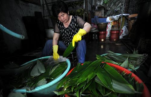 6月18日,徐桃香的女兒在清洗選自瀏陽山區(qū)的粽葉。新華社記者 李尕 攝