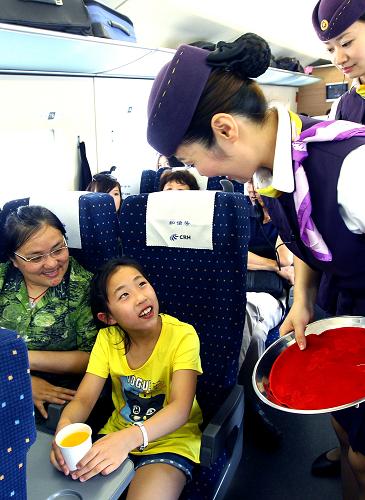 6月29日,京滬高鐵上??瓦\段乘務員正在開往北京的列車上為旅客提供服務。新華社記者 陳飛 攝