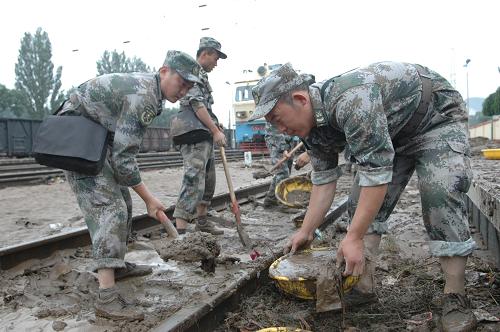 7月26日,解放軍某部官兵在清理鐵軌上的淤泥。 經(jīng)過(guò)呼和浩特鐵路部門(mén)和駐地部隊(duì)10個(gè)多小時(shí)奮力搶修,京包鐵路集寧至呼和浩特區(qū)間受洪水影響而中斷的路段,7月26日10時(shí)許已全線搶通。 據(jù)了解,7月25日晚,內(nèi)蒙古中部局部地區(qū)持續(xù)強(qiáng)降雨,京包鐵路集寧至呼和浩特間部分區(qū)段先后出現(xiàn)險(xiǎn)情,導(dǎo)致24趟列車(chē)晚點(diǎn)或停運(yùn)。 新華社發(fā)(解坤民 攝)
