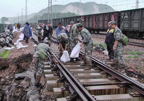 7月26日,解放軍某部官兵在加固被洪水淘空的鐵軌路基砂石。新華社發(fā)(解坤民 攝)