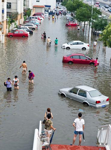 7月26日,天津市河?xùn)|區(qū)靖江路旁的車輛浸泡在積水中。新華社記者岳月偉攝