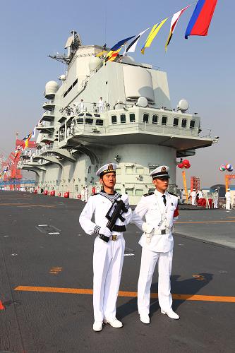 9月25日,“遼寧艦”懸掛滿旗,艦員精神抖擻分區(qū)列隊。新華社記者 查春明 攝