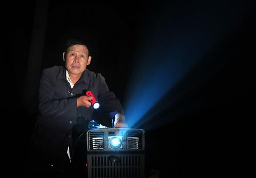 這是湖北省麻城市鹽田河鎮(zhèn)的電影放映員丁頌揚(yáng)在準(zhǔn)備放映設(shè)備(2011年10月12日攝)。新華社發(fā)