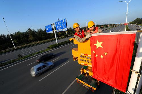 9月26日,天津電力路燈處的工作人員在衛(wèi)國(guó)道快速路懸掛五星紅旗。新華社發(fā)(王大偉 攝)