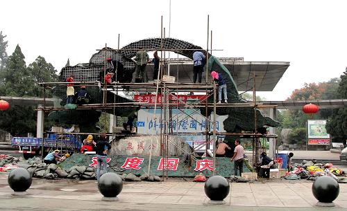 9月26日,濟(jì)南園林工人在經(jīng)十路搭建大型植物立體造型。新華社記者 徐速繪 攝