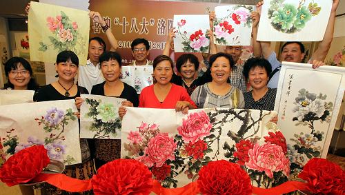 9月28日,來自洛陽市平樂村11位牡丹畫師在展覽現(xiàn)場(chǎng)。新華社記者 張明 攝