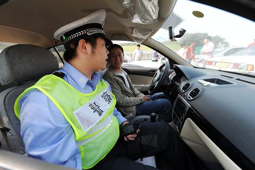 10月21日,杭州市高速交警第五大隊的一位交警(左)為一位結(jié)束訓練的駕駛員講解駕駛中存在的問題。新華社記者 鞠煥宗 攝