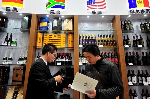 在第87屆全國秋季糖酒商品交易會上,客商(右)在咨詢世界各國進(jìn)口葡萄酒的情況(10月18日攝)。新華社記者 魏培全 攝