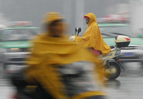 11月3日,安徽阜陽(yáng)街頭,行人冒雨騎行在路上。新華社發(fā)(盧啟建 攝)