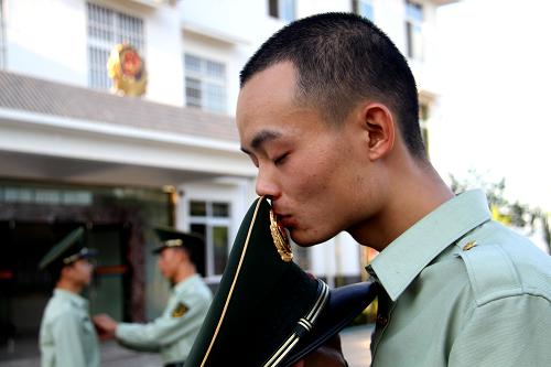 11月23日,一名老兵親吻軍帽上的國徽。新華社發(fā)(韓長春 攝)