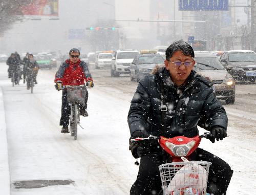 12月20日,呼和浩特市的市民冒雪出行。新華社記者 劉懿德 攝