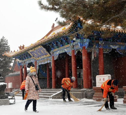12月20日,環(huán)衛(wèi)工人在清掃“大召無量寺”附近的積雪。新華社記者 劉懿德 攝