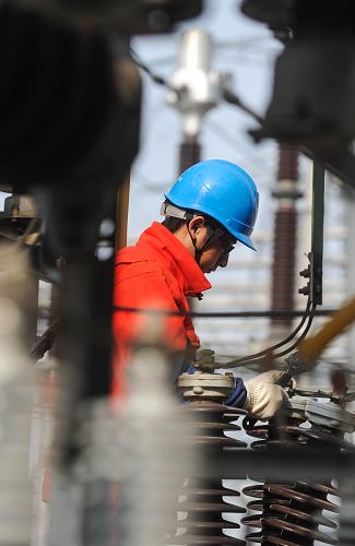 12月24日,湖州電力局的工作人員在檢修一座500千伏變電所的一個(gè)電容器組,確保設(shè)備安全運(yùn)行。新華社記者 徐昱 攝