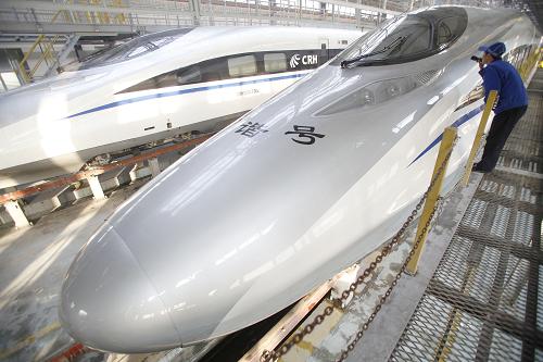 12月25日,在北京動車段北京西動車運(yùn)用所,地勤機(jī)械師在檢查車頭雨刷器。這輛車號為CRH380A-6120L的動車組將運(yùn)行明天從北京西站開出的G801次首列京廣高鐵。新華社記者 王申 攝
