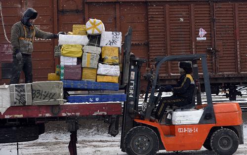 12月25日,在阿拉山口火車站內(nèi),裝卸工在雪中裝卸貨品。新華社記者 趙戈 攝
