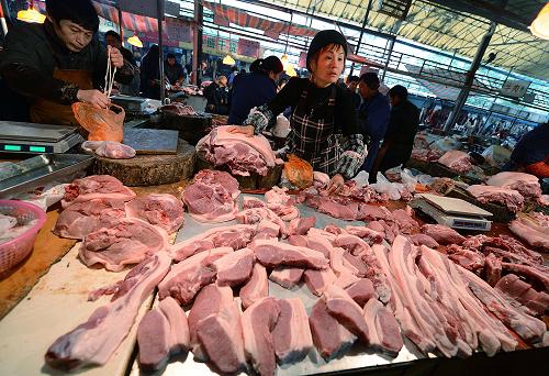 江西南昌市東湖區(qū)一家農(nóng)貿(mào)市場的攤主在叫賣豬肉(12月22攝)。新華社記者 周科 攝