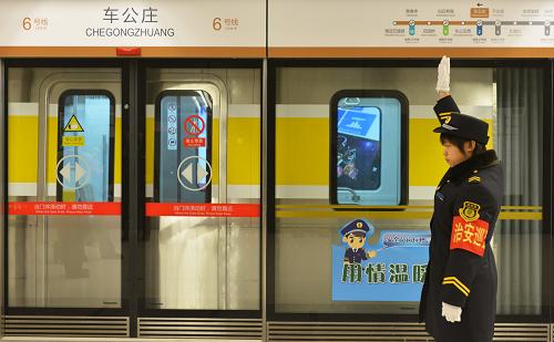 12月30日,地鐵6號線車公莊站的一名工作人員示意列車可以出發(fā)。新華社發(fā)(王全超 攝)