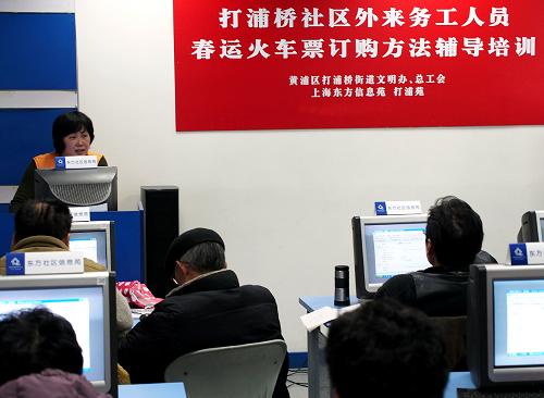 1月7日,工作人員正在輔導外來務工者學習網(wǎng)上購買春運火車票的方法。新華社記者 陳飛 攝
