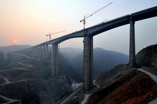 鄭(州)盧(施)高速公路上高達120米的大鐵溝特大橋正在施工中(2012年12月25日攝)。隨著總里程348.2公里的豫西5條高速公路于2012年年底全部建成通車,河南省實現(xiàn)了所有縣(市)20分鐘上高速的目標,在全國率先實現(xiàn)“縣縣通高速”,并以5800公里的高速公路總通車里程,連續(xù)七年位居全國第一。新華社記者 王頌 攝