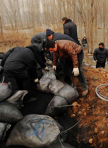 1月8日,工作人員在岳城水庫(kù)上游漳河香水河支流一處工作點(diǎn)投放活性炭。新華社發(fā)(朱旭東 攝)