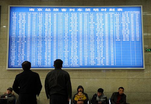 1月9日,兩位旅客在南京火車站售票廳看列車時(shí)刻表。新華社記者 孫參 攝