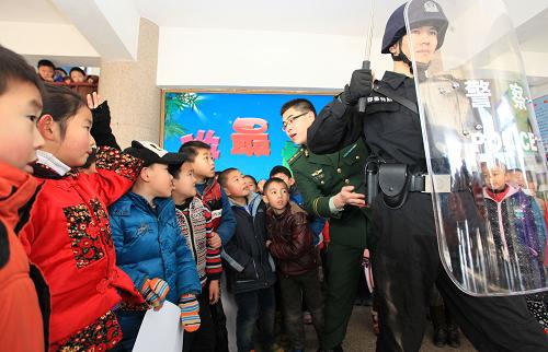 1月10日,山東省即墨市公安局民警在即墨市第三實驗小學(xué)向?qū)W生們展示出警中的基本技能。新華社發(fā)(梁孝鵬 攝)