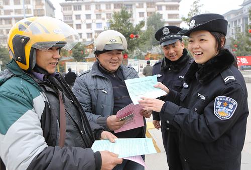 1月10日,在廣西融水苗族自治縣蘆笙文化廣場,融水縣公安局民警龐榮(右一)向居民介紹如何正確撥打110電話。新華社發(fā)(龍濤 攝)