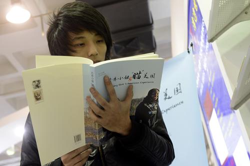 1月10日,一名讀者在2013北京圖書訂貨會預(yù)展會上閱讀圖書。新華社發(fā)(劉玉和 攝)