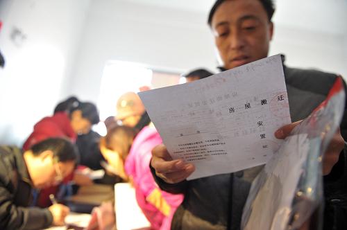 1月11日,回遷居民在排隊(duì)領(lǐng)取《房屋搬遷安置證》。新華社記者 郭晨 攝